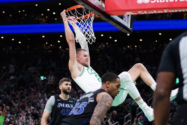 Jun 6, 2024; Boston, Massachusetts, USA; Boston Celtics center Kristaps Porzingis (8) dunks against Dallas Mavericks forward P.J. Washington (25) and forward Maxi Kleber (42) in the third quarter during game one of the 2024 NBA Finals at TD Garden. Mandatory Credit: David Butler II-USA TODAY Sports