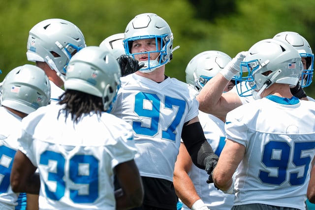 Detroit Lions defensive end Aidan Hutchinson (97) huddles with teammates at practice during mini camp at Detroit Lions headquarters and practice facility in Allen Park on Tuesday, June 4, 2024.