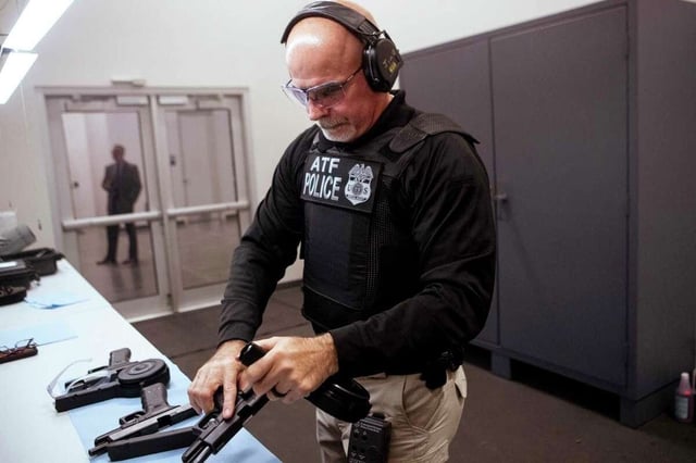 Special Agent James O'Flaherty, a firearms instructor coordinator for ATF field agents, demonstrates a handgun fitted with a "Glock switch" in Houston. (Credit: Brett Coomer/Houston Chronicle)