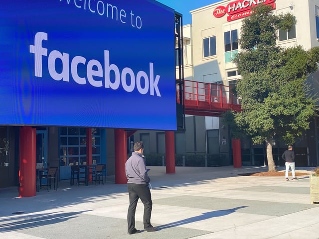 An employee of the Internet company Facebook walks through the courtyard of the company campus in Menlo Park, California.