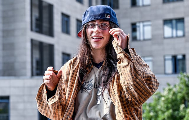 Billie Eilish is sitting on a ledge of a staircase railing known as the 'Billie Eilish wall' in Berlin on June 7, 2024 CREDIT: Britta Pedersen/picture alliance via Getty Images
