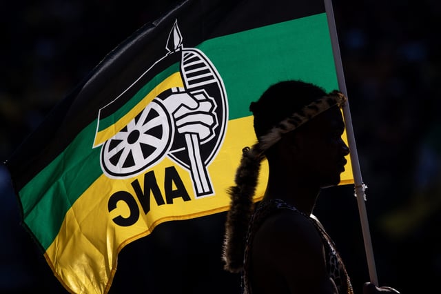 JOHANNESBURG, SOUTH AFRICA - MAY 25: A performer holds an ANC flag while listening to President of the ruling African National Congress (ANC) and South African President, Cyril Ramaphosa speak during the ANC Siyanqoba Rally held at FNB Stadium on May 25, 2024 in Johannesburg, South Africa. South Africa's national and provincial elections will be held on 29 May 2024 to elect a new National Assembly and provincial legislature in each of the nine provinces. (Photo by Chris McGrath/Getty Images)