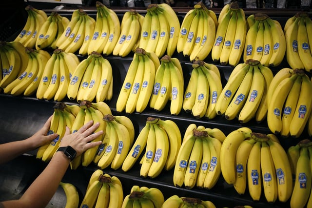 An employee arranges Chiquita Brands International Inc. bananas in the produce department inside a Kroger Co. grocery store in Louisville, Kentucky, on Wednesday, June 14, 2017.