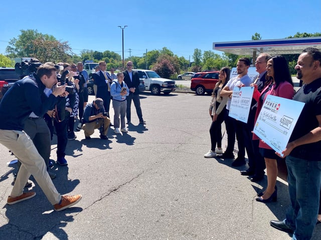 The Michigan Lottery presents two checks -- one for the $842.4 million winning Powerball jackpot ticket and the other to the local business that sold it -- Tuesday, June 11, 2024, at Grand Blanc retailer where it was sold.