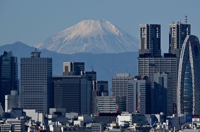 Mt. Fuji can be seen in the background between skyscrapers in Tokyo’s Shinjuku area on Nov. 14, 2023.