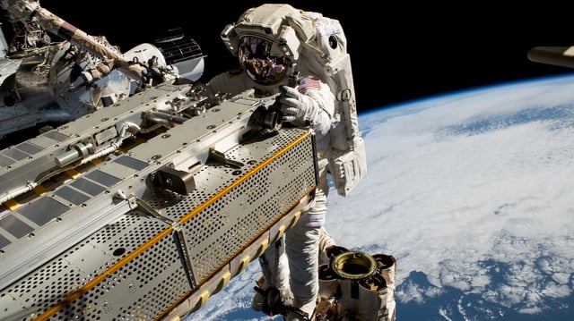NASA astronaut and Expedition 68 Flight Engineer Woody Hoburg rides the Canadarm2 robotic arm while maneuvering a roll-out solar array toward the International Space Station's truss structure 257 miles above the Pacific Ocean.