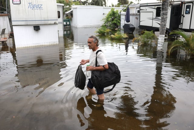 J.P. Pasqual walks through flood water in Hallandale Beach, Fla., on Thursday.