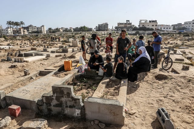 Palestinians visit the graves of their relatives who were killed during the ongoing war in the cemetery, on the first day of Eid al-Adha, in Deir al-Balah in the central Gaza Strip. Photo: dpa