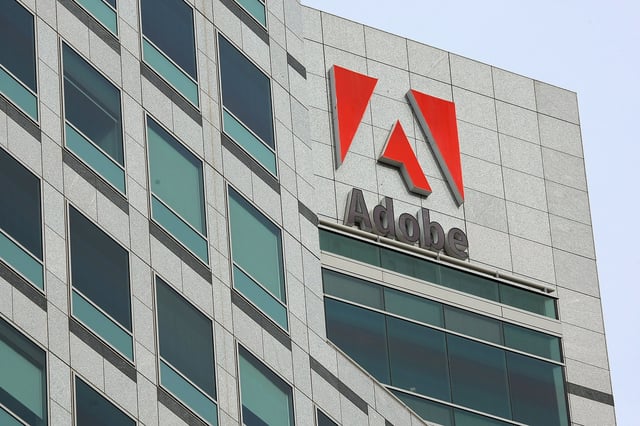SAN JOSE, CA - JANUARY 15: The Adobe logo is displayed on the side of the Adobe Systems headquarters January 15, 2010 in San Jose, California. Adobe Systems has added 20 new wind turbines to their rooftops in an attempt to harness wind energy to help power their offices. Each 30 foot tall aluminum wind turbine is capable of capturing a maximum of 1.2 kilowatts of electricty. (Photo by Justin Sullivan/Getty Images)