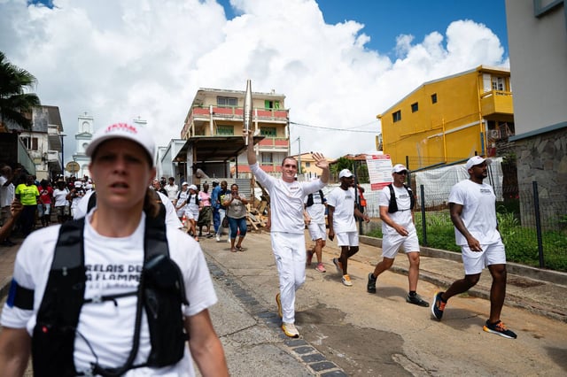 A torch-bearer runs with the Olympic flame during the torch relay in Sainte-Marie, in the French Caribbean island of Martinique. Photo: AFP