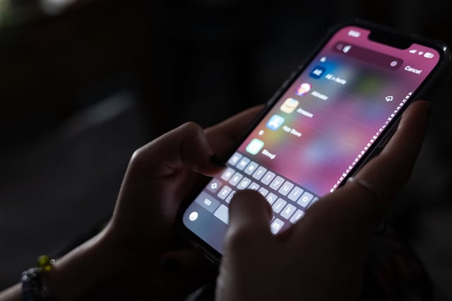 In this photo illustration, a teenager uses her mobile phone to access social media on January 31, 2024 in New York City. Technology executives appeared at a Senate hearing to address accusations that their companies are endangering children's lives by not adequately policing predators and others who seek to harm and exploit young social media users.