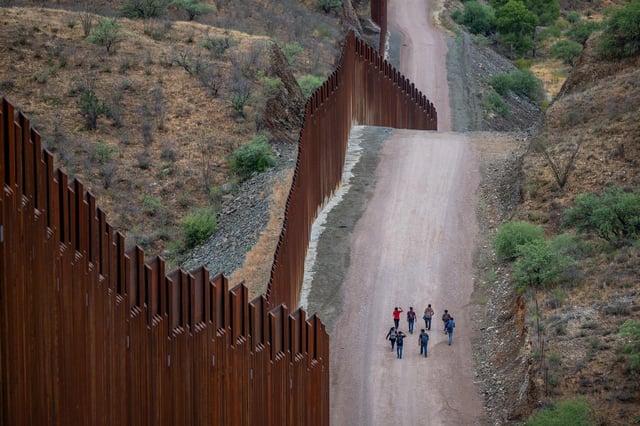 RUBY, ARIZONA - JUNE 24: Migrants seeking asylum from Central and South America walk alongside border fencing after illegally crossing over into the U.S. on June 24, 2024 in Ruby, Arizona. President Joe Biden has announced an immigration relief plan, which promises a path to citizenship for approximately 500,000 undocumented immigrants married to or adopted by U.S. citizens. Day's after Biden's announcement, Republican presidential candidate, former U.S. President Donald Trump announced to a podcast host that he would solidify green cards for foreign nationals who've received a U.S. college diploma. (Photo by Brandon Bell/Getty Images)