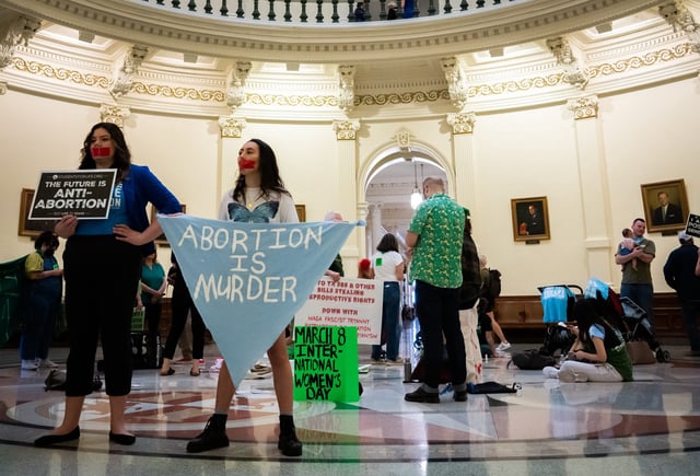 Sarah Zarr, left, from Students for Life of America, and Melanie Salazar, from the Progressive Anti-Abortion Uprising, stand on the Texas State Capitol Rotunda to protest an International Women's Day Sit-In for Abortion Rights, March 8, 2023.