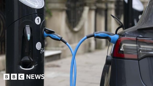 A car charging at an charge point in London. A big blue cable connects the two.