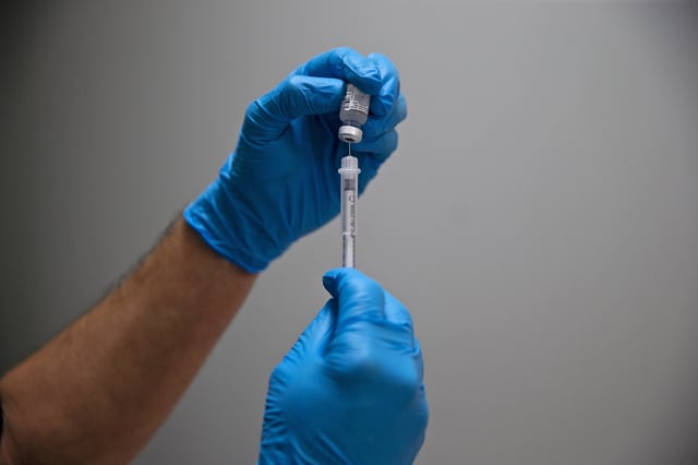 A pharmacist prepares a Covid-19 vaccine for a patient in Gorham, Maine, in 2022.