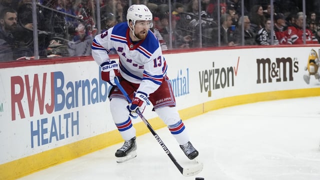 FILE - New York Rangers' Alexis Lafrenière skates with the puck during the second period of an NHL hockey game against the New Jersey Devils on March 30, 2023, in Newark, N.J. The Rangers have signed Lafrenière to a two-year contract worth $4.65 million, according to his agent, Wednesday, Aug. 23. He'll count just over $2.3 million against the salary cap each of the next two seasons. (AP Photo/Frank Franklin II, File)