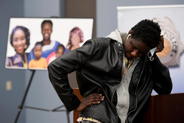 Abou Diol holds his head next to a picture of his brother, Djibril Diol, at Denver Police Crime Laboratory in 2021. Photo: The Denver Post via AP