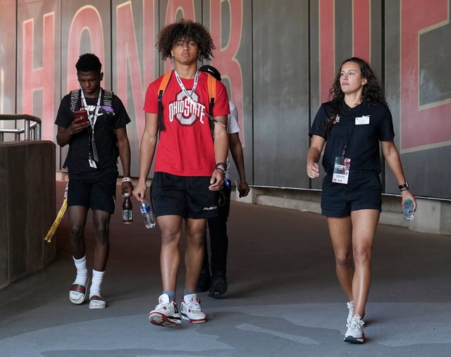 Ohio State football recruit Justin Hill, center, walks down the tunnel toward the field at Ohio Stadium before the spring game on April 15.