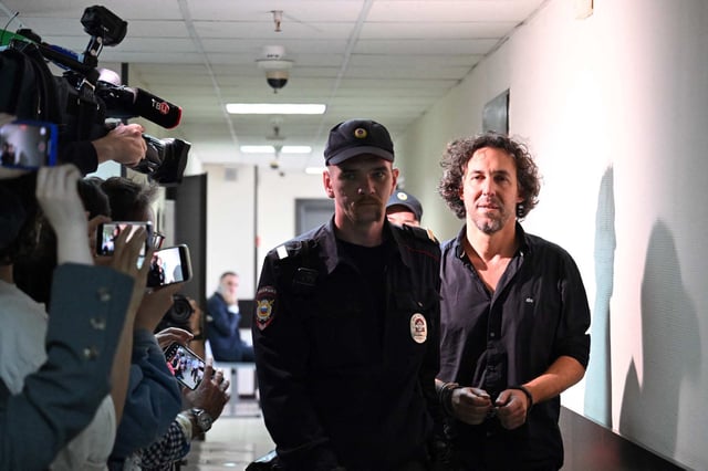 Laurent Vinatier is escorted by a Russian law enforcement officer before his pre-trial detention hearing in Moscow. Russia’s security services accuse him of collecting military information. Photo: AFP