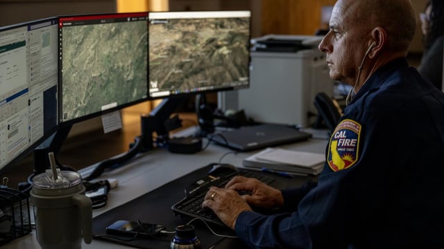 MORENO VALLEY, CA - AUGUST 9, 2023: Cal Fire Ted Schaffer monitors computer screens which depicts views of wildfire camera systems in real time throughout the state of California at the Southern California Geographic Area Coordination Center on August 9, 2023 in Moreno Valley, CA. The agency is using AI to help monitor the camera systems.(Gina Ferazzi / Los Angeles Times)