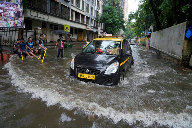 A car drives through a flooded street after heavy rainfall in Mumbai, India on Monday. Photo: AP