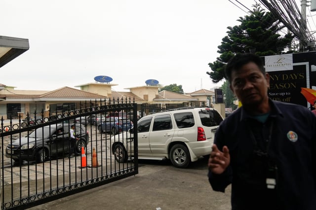 A security person tries to block a photographer outside the Lake Hotel in Tagaytay city. Photo: AP