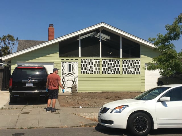 A neighbor helps clean blood from the house on Kitty Hawk Road in Alameda where police belive a man killed his wife, son and in-laws. Another, 1-year-old son, was in critical condition following the shooting. 