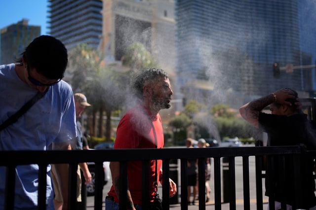 People cool off in misters along the Las Vegas Strip, Sunday, July 7, 2024.