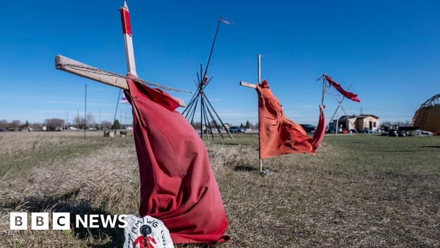 Red dresses on crosses are displayed at the entrance of a makeshift camp near near the Prairie Green landfill in Winnipeg, Manitoba