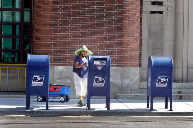 A customer mails a letter. The price of a postage stamp is going up 5 cents on July 14 to 73 cents.