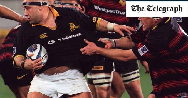 Norm Hewitt of Wellington, with the ball, has his shirt grabbed by Canterbury's David Hewett in 2000 