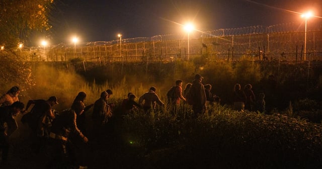 Migrants walk through the mostly dry river bed of the Rio Grande to concertina wire guarded by Texas National Guard soldiers along the U.S.-Mexico border in Ciudad Juarez, Chihuahua state, Mexico on May 27, 2024. Migrants trying to cross into El Paso, must first make it through an area between concertina wire and the border wall, and not be caught by Texas National Guard soldiers, in order to turn themselves in to B…
