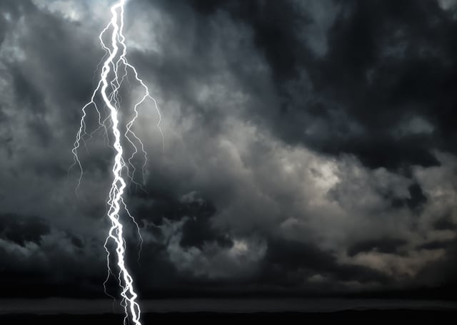 A computer generated image of a dark cloudy sky with lightning .