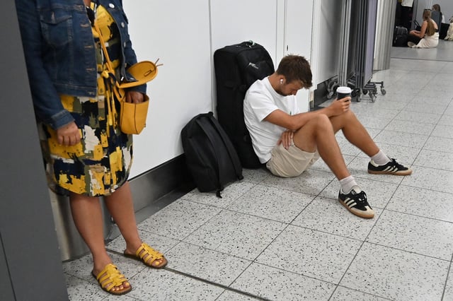 A passenger waits in the check-in area of Gatwick Airport as some flights are cancelled or delayed, in Horley, south of London on July 20, 2024.