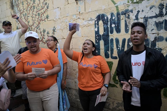 Supporters of Venezuelan President Nicolas Maduro hand out flyers in the neighborhood of Agua de Maiz in Caracas on July 11, 2024.