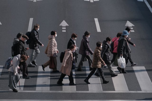 Pedestrians cross an intersection in the Itabashi district of Tokyo, Japan, on Jan. 19, 2024.