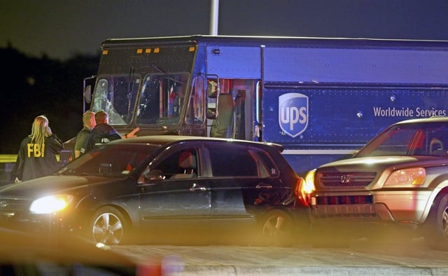 Law enforcement stand near a vehicle that appears to be part of the crime scene Thursday, Dec. 5, 2019, in Miramar, Fla. A Florida police union leader blasted prosecutors Monday, July 29, 2024, for charging four officers with the 2019 shootout with two robbers that left a hijacked UPS driver and a passerby dead, saying they had no choice but to return fire on a busy suburban street. (Charles Trainor Jr./Miami Herald via AP, File)