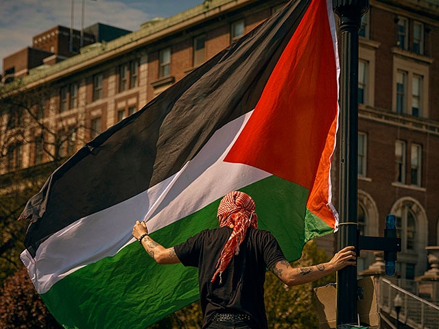 A protester places a Palestinian flag at a pro-Palestinian encampment at Columbia University, in New York, Sunday, April 28, 2024, advocating for financial disclosure and divestment from all companies tied to Israel and calling for a permanent cease-fire in Gaza. (AP Photo/Andres Kudacki)
