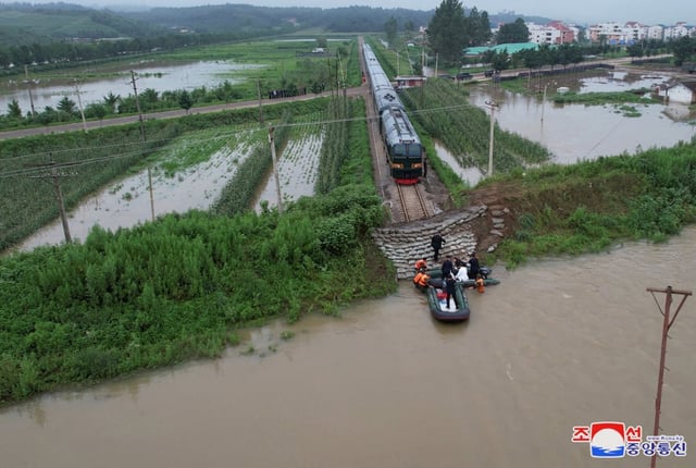 North Korean leader Kim Jong-un walks up an embankment towards a train during a visit to a flood-affected area near the border with China. Photo: Reuters
