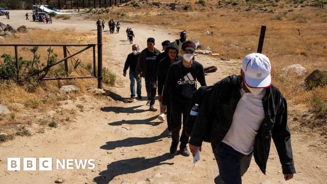 Migrants walk on a road waiting to be processed by the U.S. Border Patrol near the Jacumba Hot Springs after crossing the US-Mexico border on June 13, 2024 in San Diego, California.