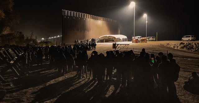 Illegal aliens wait to be transported on Border Patrol buses after crossing the U.S.-Mexico border into Yuma, Arizona, on Dec. 20, 2022. (Qian Weizhong/VCG/Getty Images)