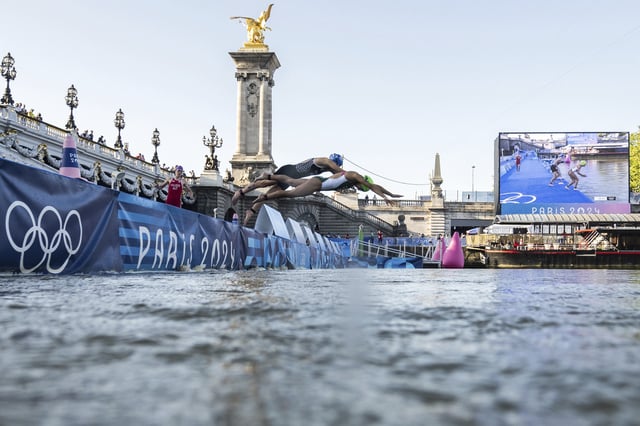 Athletes jump into the water to compete in the swimming race in the Seine river, during the mixed relay triathlon, at the 2024 Paris Summer Olympics on Monday, Aug. 5, 2024.