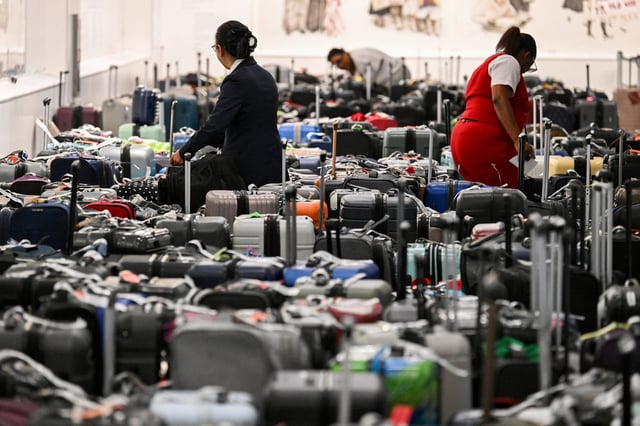 Delta employees look through bags awaiting reunification with their owners in the Delta Air Lines baggage claim area at LAX on July 24, 2024.