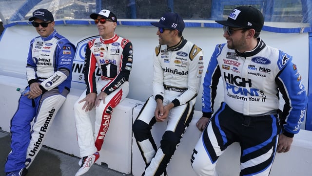Ryan Preece, Kevin Harvick, Aric Almirola and Chase Briscoe, from left, talk before a practice session for the NASCAR Cup Series auto race at Indianapolis Motor Speedway, Saturday, Aug. 12, 2023, in Indianapolis. (AP Photo/Darron Cummings)