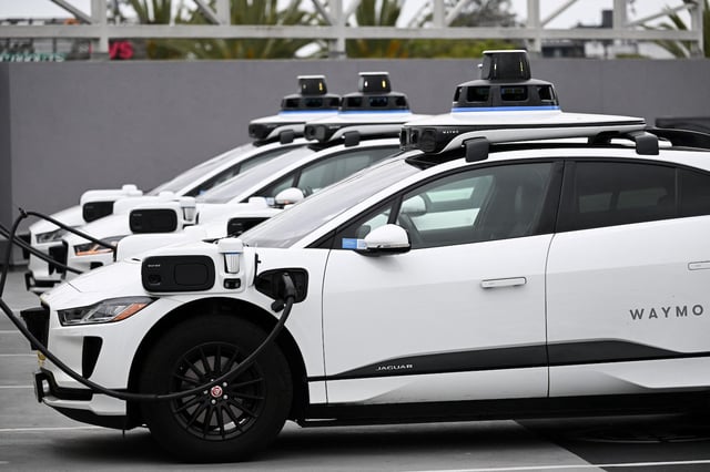 A Waymo autonomous self-driving Jaguar electric vehicle sits parked at an EVgo charging station in Los Angeles, California, on May 15, 2024. The top US auto safety regulator on Tuesday said it had opened an investigation into Google-owned Waymo after reports of 22 incidents with its self-driving technology. The National Highway Traffic Safety Administration's (NHTSA) Office of Defects Investigation said the problems took place in vehicles equipped with Waymo's fifth generation automated driving system. (Photo by Patrick T. Fallon / AFP)