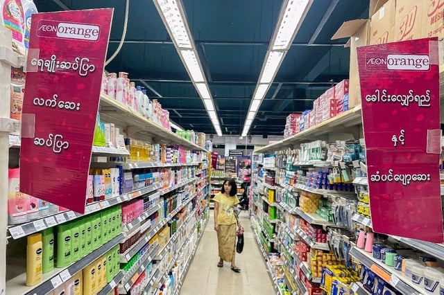 A shopper walks down an aisle at an Aeon Orange supermarket in Yangon on July 1, after Myanmar authorities arrested a Japanese national working for the retail giant for allegedly selling rice at artificially high prices