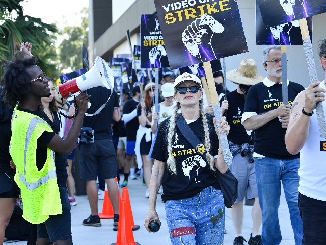 US actress Frances Fisher (C) strikes with SAG-AFTRA union video game performers outside Warner Bros. Games, part of the Global Streaming and Interactive Entertainment unit of Warner Bros. Discovery, in Burbank, California, on August 1, 2024. Artificial intelligence was key to 2023's Hollywood strikes, and it has now sparked a second walkout by those actors who work in a far larger industry, video games. The union on July 26, 2024, began its second strike in nine months, this time against gaming giants that dominate an industry which grosses well over $100 billion each year. (Photo by VALERIE MACON / AFP)