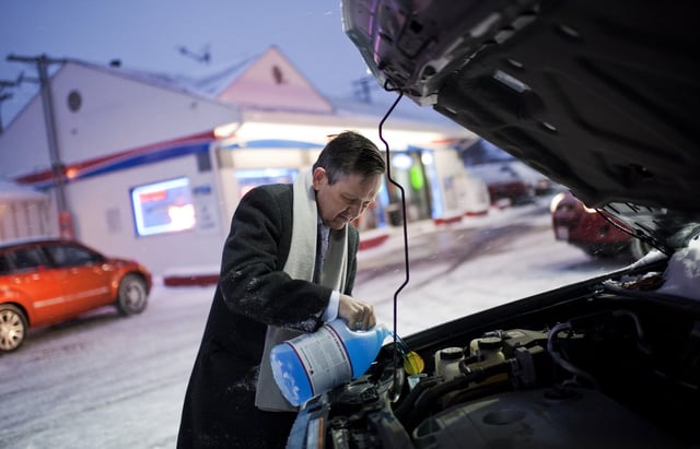 A Man Pouring Antifreeze Into Car