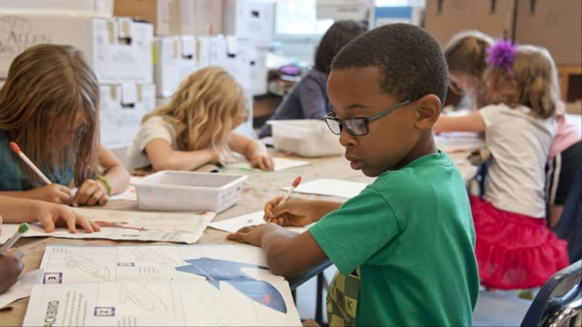 Children in a classroom working with their supplies