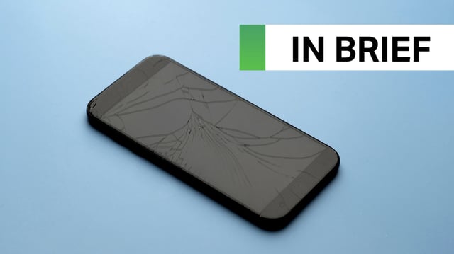 A broken phone on a blue table background. (Image: Wong Yu Liang/Getty Images)